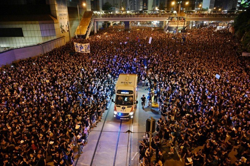 香港6月的反送中游行,救护车经过游行队伍,抗争人士主动让道。