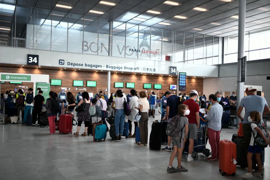 2020年8月,法国机场,戴着口罩的乘客在排队等候登机。(示意图/非本文图片/图片来源:STEPHANE DE SAKUTIN/AFP via Getty Images)
