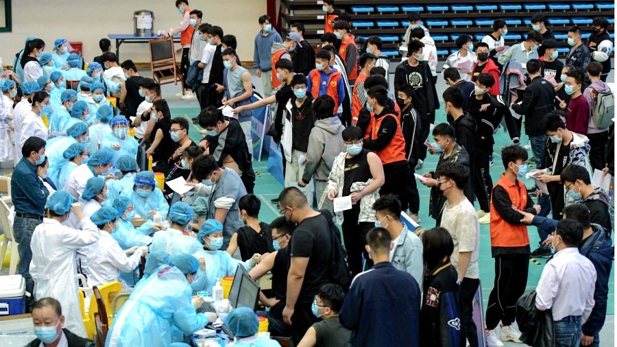 这张摄于2021年3月30日的照片显示,大学生正在山东省青岛市的一所大学排队接种疫苗。(图片来源:STR/AFP via Getty Imges)
