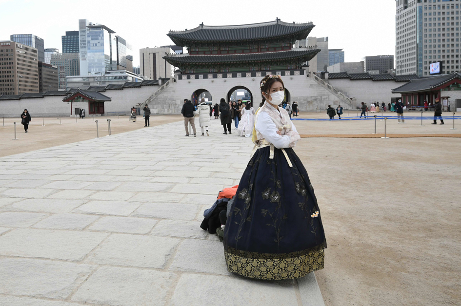 一名身穿韩国传统韩服的女子站立在首尔景福宫前。(JUNG YEON-JE/AFP via Getty Images)