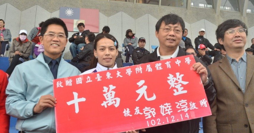 台湾“举重女神”郭婞淳(前左2)2013年拿到世界锦标赛金牌后,回到母校台东大学附属体育中学捐赠新台币10万元奖学金;她勉励学弟妹“要知恩回报,没有体中就没有现在的她”。(图片来源:中央社/卢太城)