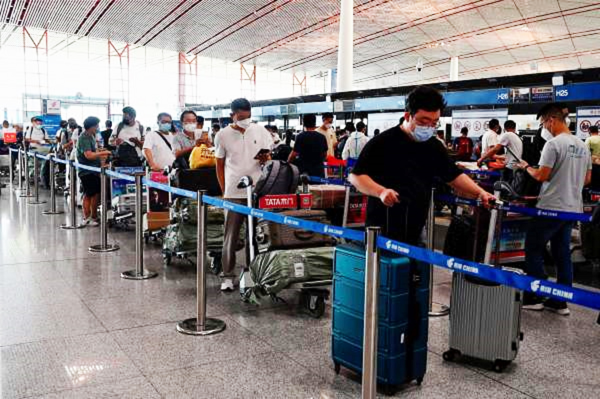 戴着口罩的乘客在北京机场排队。(JADE GAO/AFP via Getty Images)