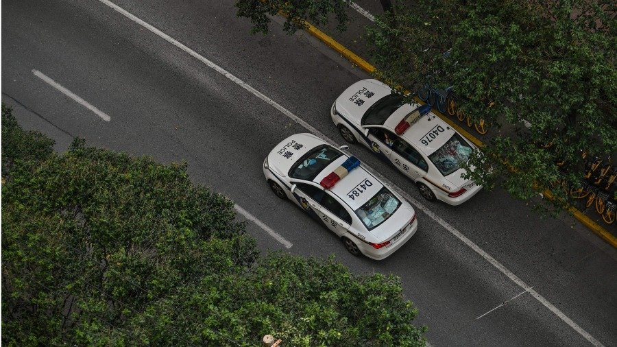 在上海静安区进行 COVID-19 封锁期间,警车在街道上行驶。(图片来源:HECTOR RETAMAL/AFP via Getty Images)