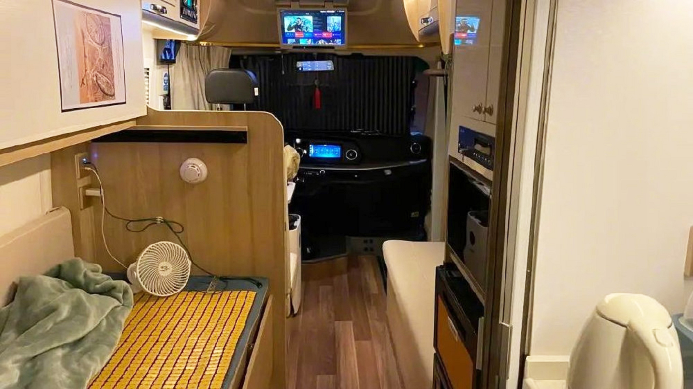小李哥在房车内可以看电视、唱K和 办公。
