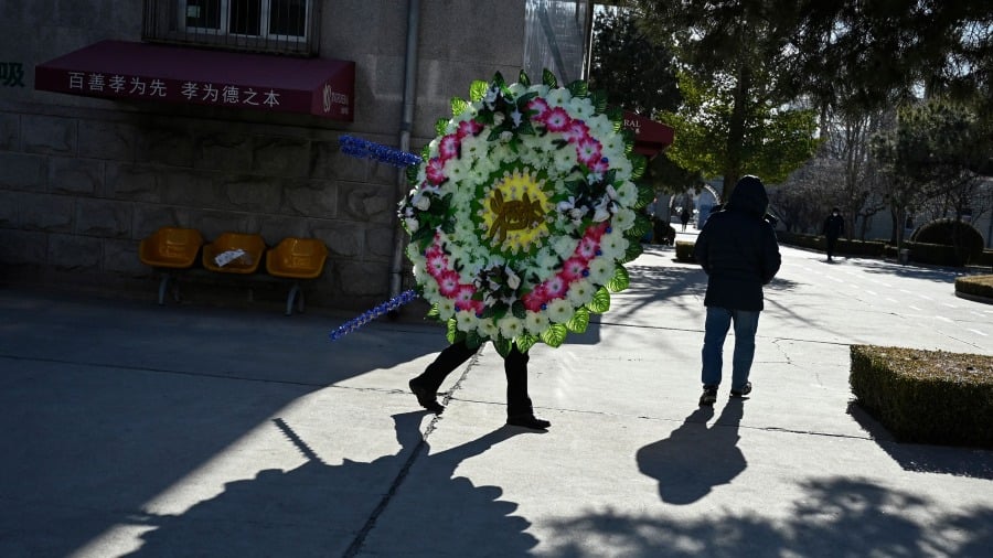 2022年12月22日在北京一家殡仪馆里一家属手持花圈。(图片来源:Getty Images)