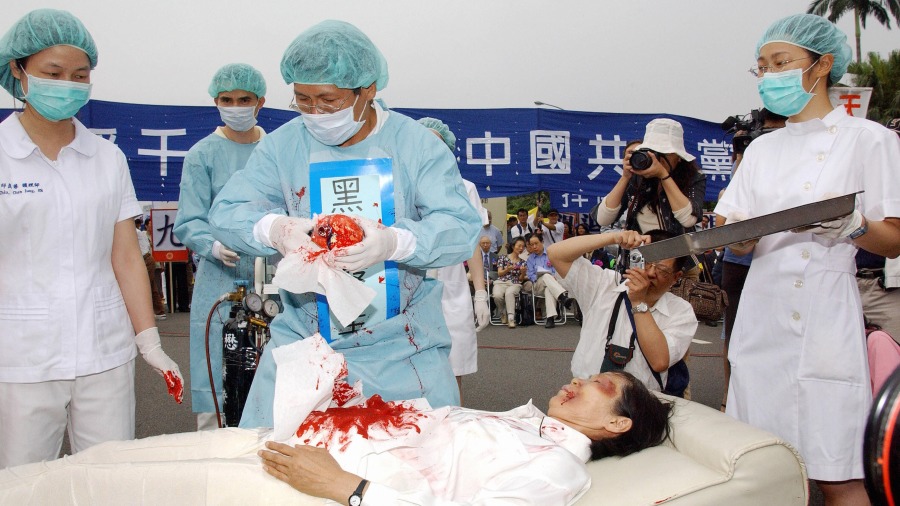 2006年4月23日,法轮功学员在一个集会中演示中共活摘法轮功学员器官。(PATRICK LIN/AFP via Getty Images)