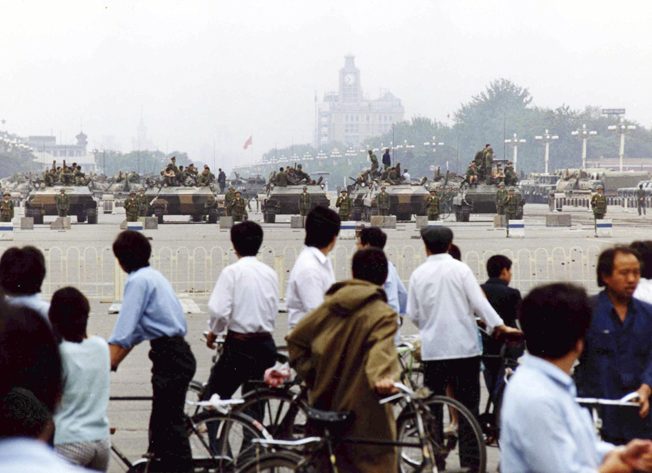 资料照片:北京市居民们在观看天安门广场上的解放军坦克车。(1989年6月7日)