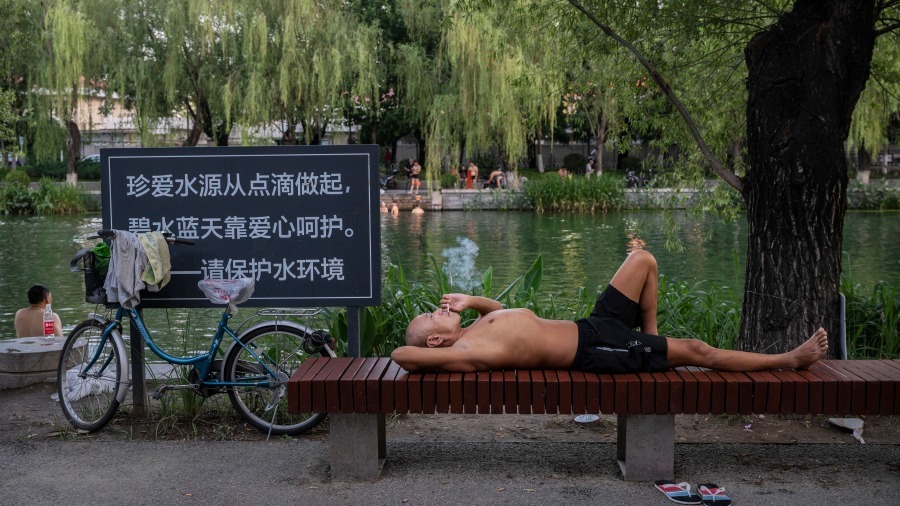 2022年7月7日北京高温天气,市民湖里游泳、湖边纳凉。(图片来源:Getty Images)