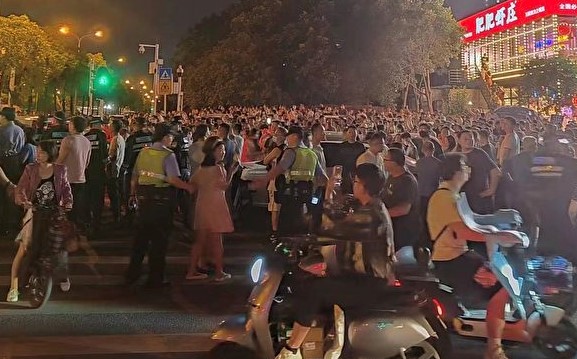 6月3日,湖北武汉市东湖高新区光谷第十五小学分流高年级的学生去三公里外的光谷第十九小学上学,引发上千家长抗议。(图片来源:翻拍网图)