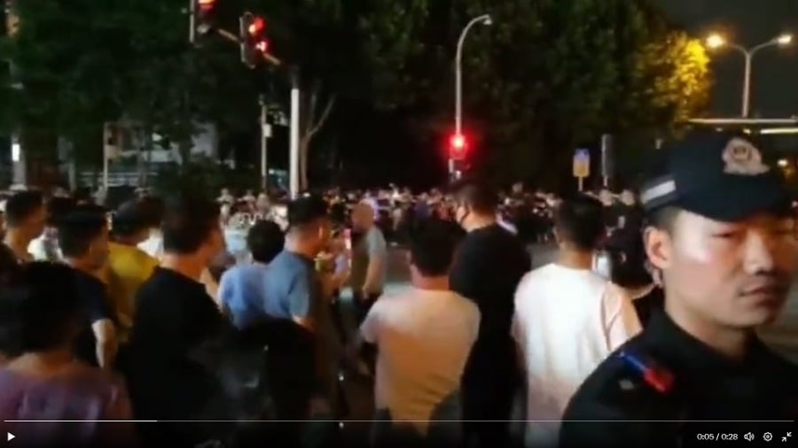 6月4日,湖北武汉市东湖高新区光谷第十五小学分流高年级的学生去三公里外的光谷第十九小学上学,引发上千家长抗议。(图片来源:视频截图)